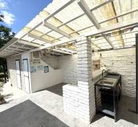 A family house in Komárno with a terrace, covered pergola, and outdoor sink.