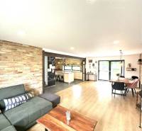 Living room in a family house with a brick wall and a wooden table.