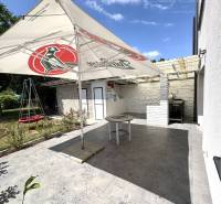 A family house in Komárno with a terrace, garden, and a swing under an umbrella.