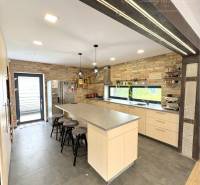A kitchen with a brick wall and an island in a family house.