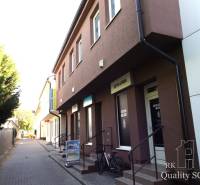 The building on Mäsiarska Street in Senec with studios and shops along the sidewalk.