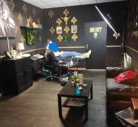 Interior of a building with a tattoo parlor, gold-colored decorations on the walls.