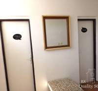 The interior of a building with two doors, a mirror, and a fire extinguisher.