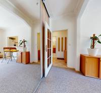Interior of a 2-room apartment with white walls, wooden furniture, and access to a balcony.