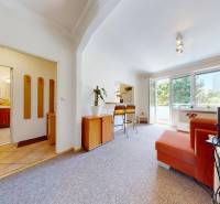 Interior of a 2-room apartment with a living room, orange sofa, and balcony.