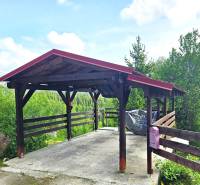 A shelter with a wooden structure by a family house in Donovaly, surrounded by greenery.