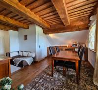 Wooden ceiling and table in the dining room of the family house with a sofa and decorations.