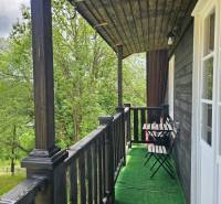 A balcony of a family house with wooden railings and a view of nature in Donovaly.