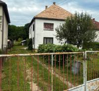 A family house in Bzovík with a garden and an old fence from the street.