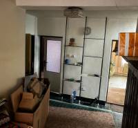 Interior of a family house with boxes, a shelf, a lamp, and room doors.