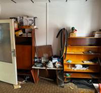 A messy room in a family house with shelving cabinets and various items.
