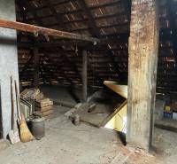 The attic of a family house with a roof and stored items in Bzovík.