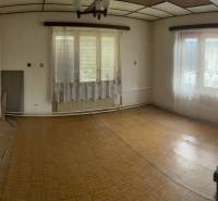 A room with parquet floors and windows with curtains in a family house.