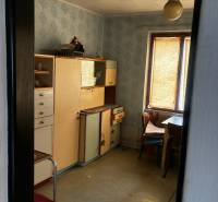 A kitchen in a family house with antique furniture and wallpaper, simple equipment.