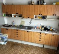 A kitchen in a family house with a wooden cabinet set and practical open shelves.