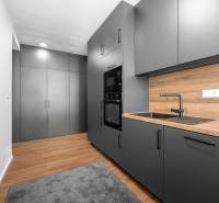 A kitchen with black cabinets and a wooden countertop in a 3-room apartment.