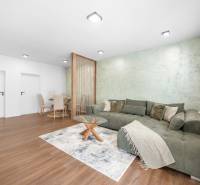 Living room in a 3-room apartment with a sofa, dining table, and wooden floor.
