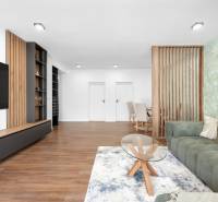 Living room with an area rug and a green sofa in a three-room apartment.