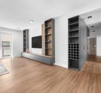 Bright living room in a 3-room apartment with wooden flooring and built-in shelves.