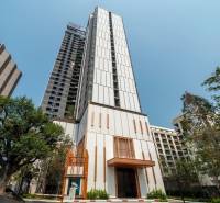 Apartment construction in Pattaya, a high-rise building with modern architecture and greenery around.