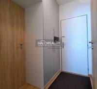The entrance hall in a studio apartment with wooden paneling and built-in wardrobes.