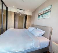 A bright bedroom with a large bed in a two-room apartment, surrounded by wooden details.