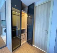 A wardrobe with open doors in a 2-room apartment, next to the kitchen area.