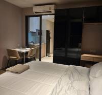 Interior of a 1-room apartment with a bed, dining table, and kitchen.