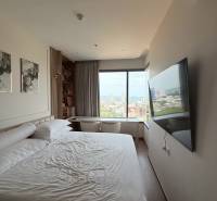 Bright bedroom in a 3-room apartment with a view, bed, and wall-mounted television.