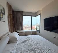 Bedroom in a 3-room apartment with a view of the city, large bed and TV.