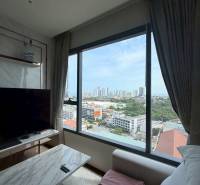Living room of a 3-room apartment with a view of the city, a comfortable couch, and a TV stand.