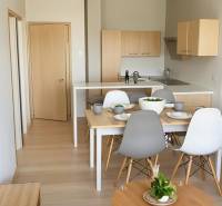 Kitchen and dining area in a 3-room apartment with wooden furniture.