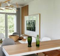 Dining table with drinks, TV on the wall, view into the garden, 3-room apartment.