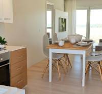 Dining table with chairs and a kitchen in a 3-room apartment with bright decor.
