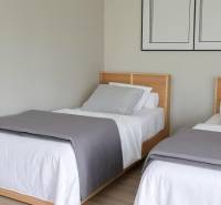 Two single beds with gray covers in a 3-room apartment.