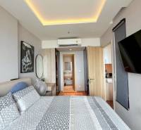 Bedroom of a 3-room apartment with patterned bedding, a mirror, and air conditioning.