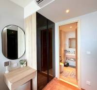 A corner with a mirror and a table in a 3-room apartment. In the background, there is a bathroom.