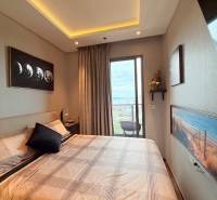 Bedroom in a 3-room apartment with a balcony, a large bed, and artistic paintings.