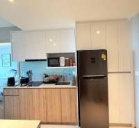 A kitchen in a 3-room apartment with wooden cabinets and a refrigerator.