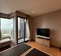 Living room in a studio apartment with a TV, sofa, and view.