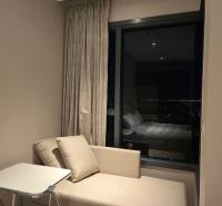 A sofa and a table in a studio apartment with a night view.