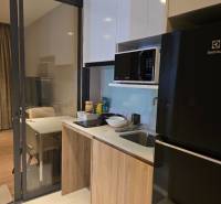 A kitchen in a studio apartment, equipped with appliances and cabinets.