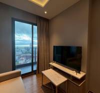 Living room in a 3-room apartment with a sofa, TV stand, and a view of the city.