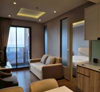 Living room in a 3-room apartment with a sofa, view, and kitchen counter.