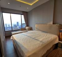 3-bedroom apartment with a bed and a view of the city and the sea.