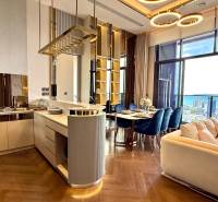 Luxury kitchen and living room with a view of the coastline in a 4-room apartment.