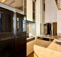 A kitchen in a 4-room apartment, with a marble countertop and a mirrored refrigerator.