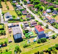 Aerial view of a residential area in Púchov, surrounded by greenery and roads.