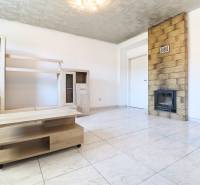 Living room with a fireplace stove and light furniture in a two-room apartment.
