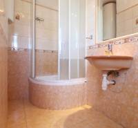 A bathroom with tiles and a shower in a 2-room apartment.